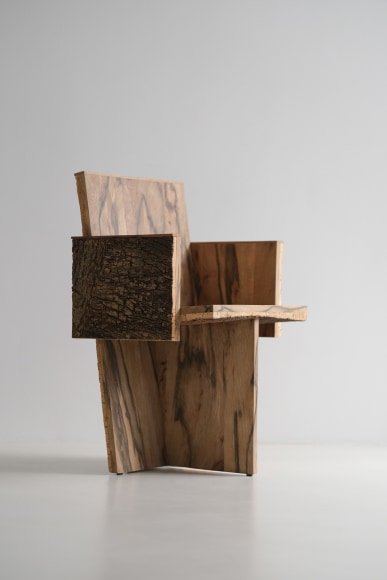 Wood and cork chair with arms and different angles photographed with a grey background.