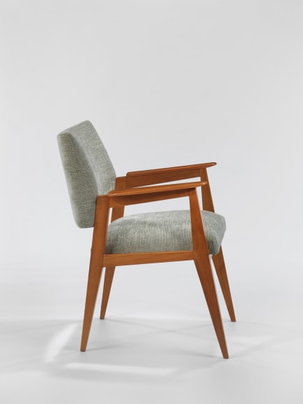 Wooden armchair with upholstered seat and back rest in front of white background