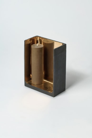 Bronze candlestick with gold detailing and black exterior.