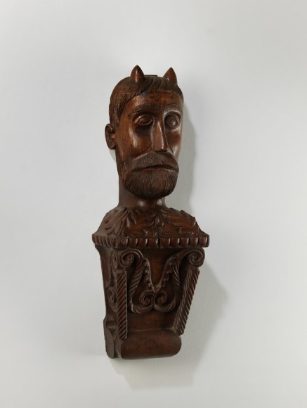 bust of a devil figure carved from wood