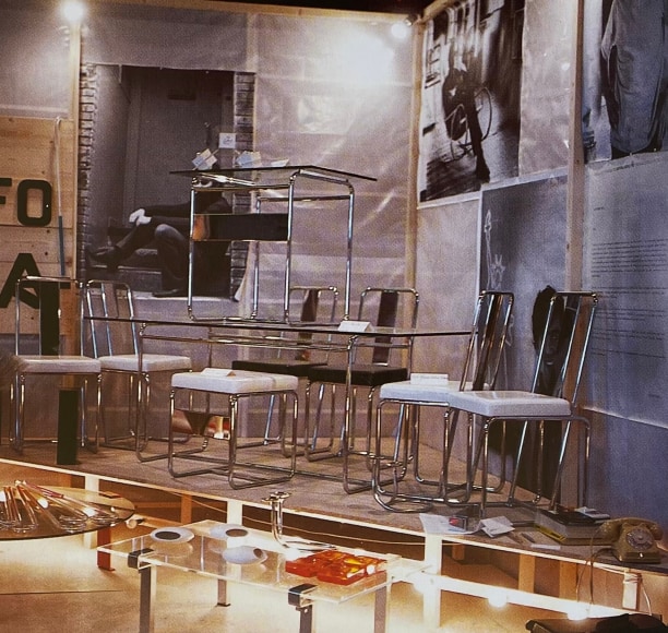 Set of tubular steel chairs, table, and desk on stage, color image