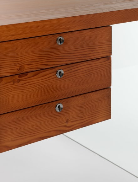 photograph of wooden desk by Motte in a blank room