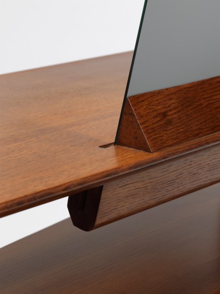 Wooden desk with a mirror in front a white background