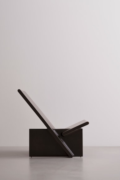 Side view of blackened bronze lounge chair with intersecting planes