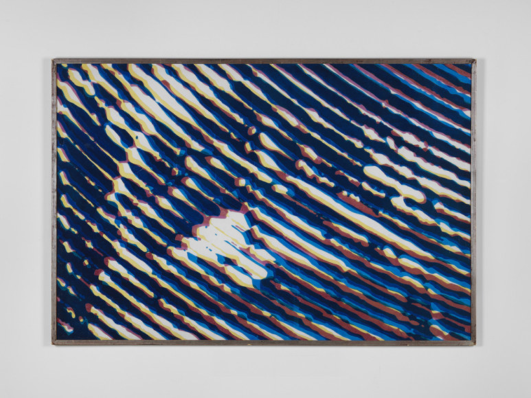 a blue piece of art by Alain Jacquet hangs on the wall