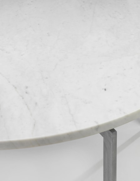 photograph of a table with steel legs and a marble top in a blank room