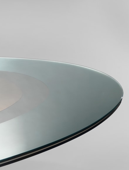 picture of a table with glass base in a gray room