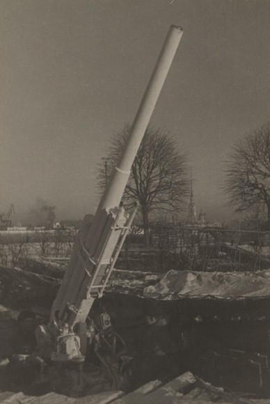 A belt of ack-ack guns girdles the city, day and night watchfully ready to repulse enemy air pirates