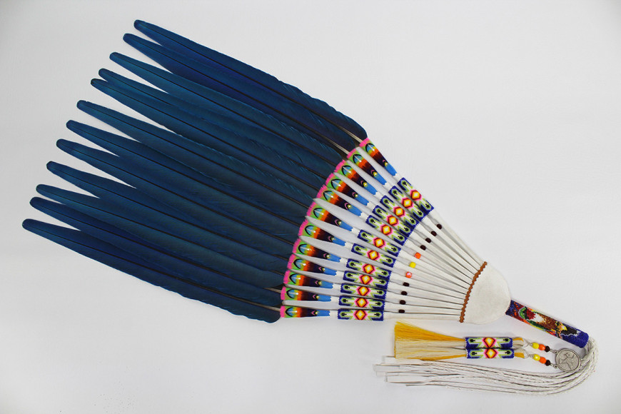 Monty Claw, Morning Blessing, 2023, blue and gold macaw tail feathers, dyed goose, rooster, and pheasant feathers, seed beads, white deer leather, tufa cast sterling silver hummingbird ornament, beaded horse hair, handmade deer leather fringe, 111.8 x 36.8 x 3.8 cm (44 x 14.5 x 1.5 inches)