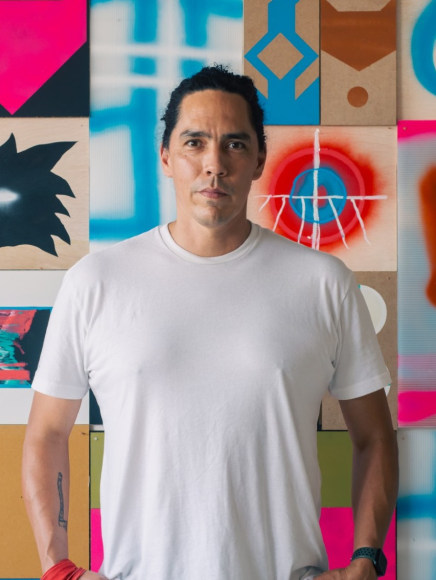 Artist Matthew Kirk standing in front of one of his paintings.