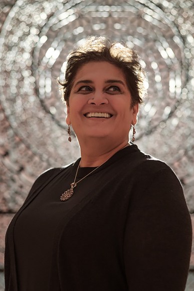 Portrait of the artist Anila Quayyum Agha in front of one of her artworks at the Philbrook Museum.
