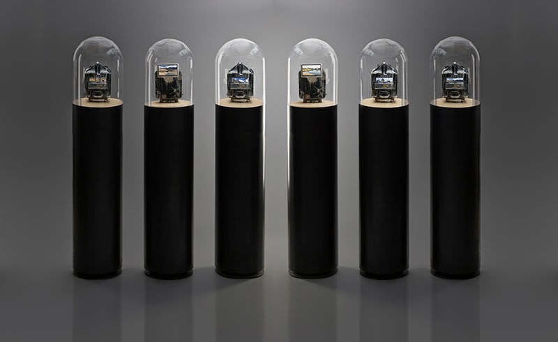 Ghiora Aharoni, The Road to Sanchi, 2016, assemblage sculpture with vintage Indian taximeter retrofitted with two screens displaying videos filmed by the artist in India, mounted on a circular wooden platform on a cylindrical steel base with a glass dome, 139.7 x 29.5 cm each (55 x 11.6 inches)