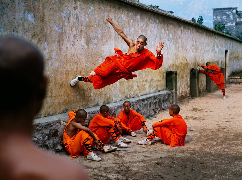 Steve McCurry, A young monk runs along the wall over his peers at the Shaolin Monastery in Henan Province, China, 2004, ultrachrome print, 101.6 x 152.4 cm (40 x 60 inches)