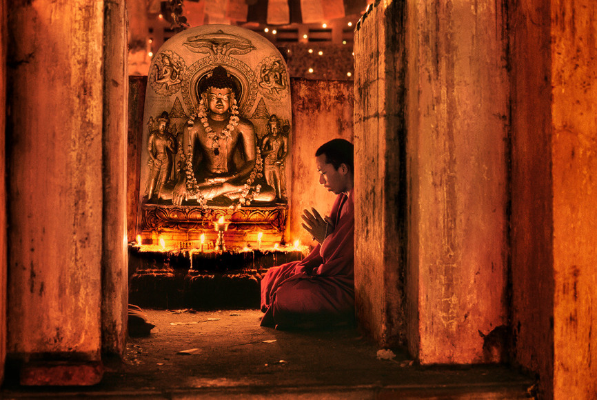 Steve McCurry, Monk Praying at Bodh Gaya, India, 2000