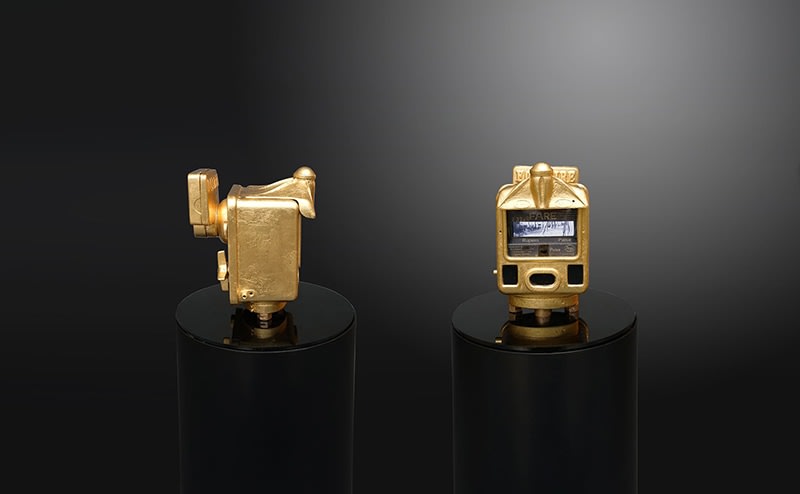 Ghiora Aharoni, When All Roads Are One, 2017, assemblage sculpture with vintage Indian taximeter encased in 23-karat gold leaf retrofitted with two screens displaying videos filmed by the artist in Sanchi, Nizamuddin (Delhi), Varanasi and Mattancherry, India, mounted on a circular black Plexiglas platform on a cylindrical steel base with a glass dome, 139.7 x 30.5 x 30.5 cm (55 x 12 x 12 inches)