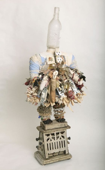 Vanessa German, Toaster, 2011, found glass bottle, hand-wrought beads: fabric, earth, string, thread, hair, mantle bird, electric outlet, cowrie, buttons, spark plugs, old doll parts, plaster, wood, wood paint, vintage match books, found toaster, image: slave ownership photograph of Delilah, found jewelry, found carved wooden banana, fabric, 31.5 x 14 x 12 inches