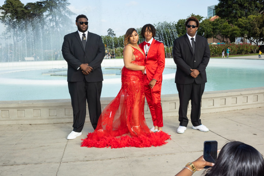 Pre-Prom Photos, Keshawn, 18, at a pre-prom photoshoot with his date Camara. Cousins A.J. and Jay play the role of bodyguards because “everyone looks nicer with a security guard,” 2022