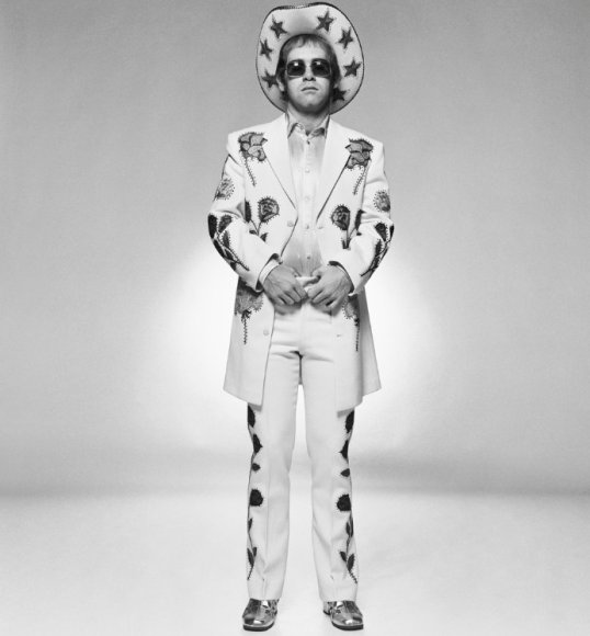 Terry O'Neill Elton John wearing a floral applique cowboy suit designed by Nudie Cohn for the cover of the "Rocket Man" single, 1972