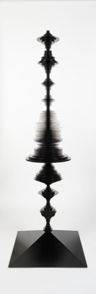 a sculpture by Elizabeth Turk of black aluminum discs layered and arranged to resemble a sound wave and a modernist abstraction