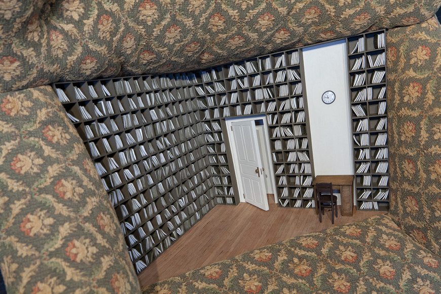 a sculpture of an armchair with a tiny library hidden in its seat