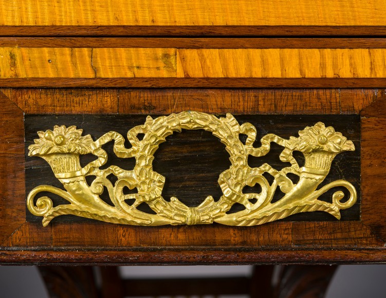 Card Table with Lyre Base, about 1815. Philadelphia. Mahogany, with gilt-brass paw toe caps and castors, strings for the lyres, and gilt-brass and ormolu mounts 28 1/2 in. high, 35 in. wide, 17 1/2 in. deep (at the top), 18 in. deep (at the castors). Detail of ormolu mount on table skirt at center.