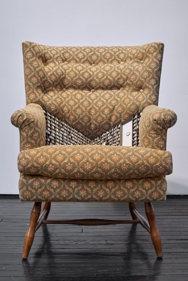 a sculpture of an armchair with a tiny library hidden in its seat