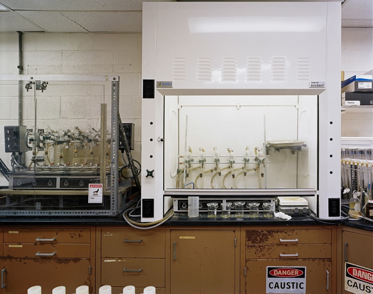 ade Doskow  Leachate Plant – Veteran’s Avenue Laboratory, 2020/2021  Archival pigment print  30h x 40w in 76.20h x 101.60w cm, interior industrial image of a laboratory in a Leachate plant, wooden counters with white machinery