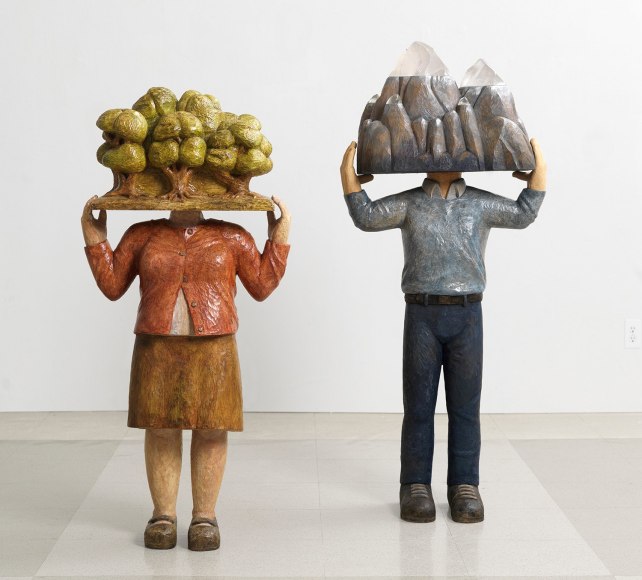 Sachiko Akiyama  On Finding Home, 2013  Wood, Paint, Gold Leaf  18 1/2h x 9 1/2w x 40d in. a sculpture featuring a figure with a mountain for a head accompanied by another statue of the same kind