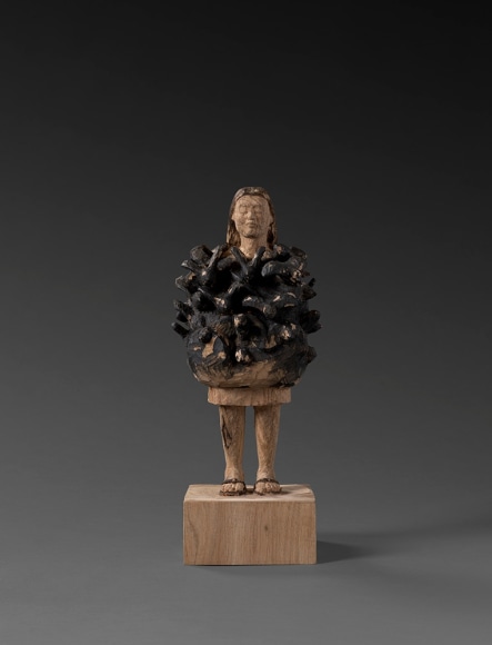 Wooden sculpture of figure covered with birds