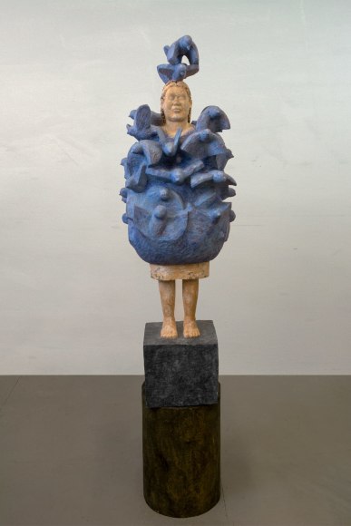 Large wooden sculpture of figure engulfed in birds.