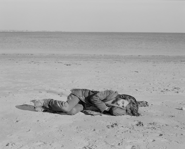 Man sleeping on beach. Photograph by Mike Smith