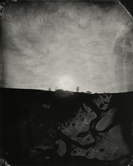 black and white tin type of the sun on the horizon