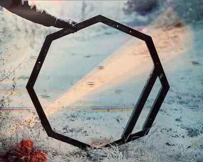 Octagonal frame in the middle of the composition with hand holding in place