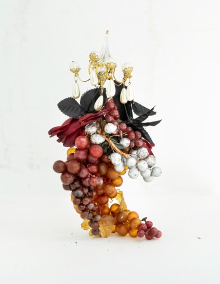 James Henkel  Fancy Grapes, 2020  20h x 16w in 50.80h x 40.64w cm  Edition 5  JHe_068 a grape vine with white, red, purple, yellow and orange grapes and a miniature chandelier placed at the top