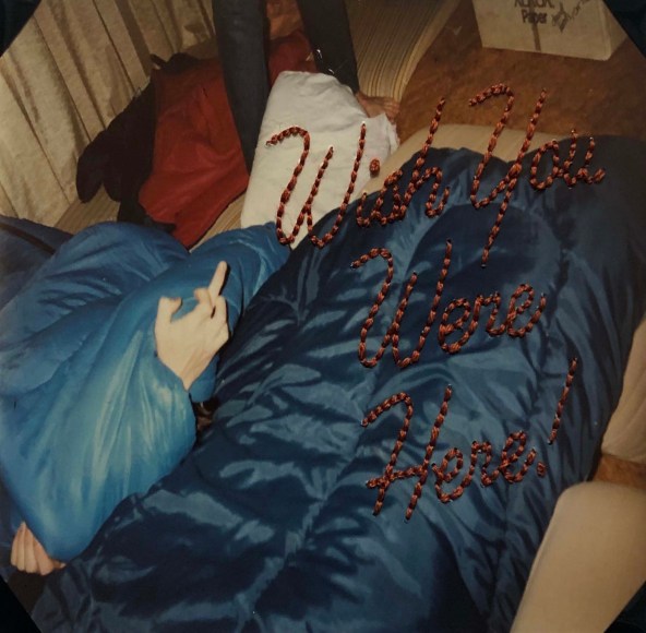 Lydia See  (David, 1996), 2020  Backstitch embroidery, family photography  3 1/2h x 5w in 8.89h x 12.70w cm  Framed: 15h x 12w in 38.10h x 30.48w cm  LS_006  $ 250.00, photo of person shooting a bird under covers, &quot;Wish you were here&quot; in text