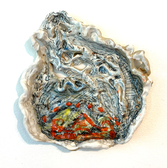 A glazed clay object. Hand painted scribbles on the textured surface. Edges are small leaf shapes