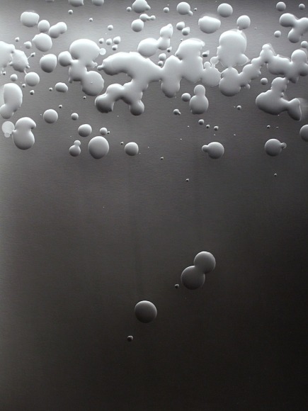 Ben Nixon  You'll Know When You Get There, 2017  unique silver gelatin photogram  Framed: 23h x 18 1/2w in. a dark background with droplets of liquid corralled at the top of the image