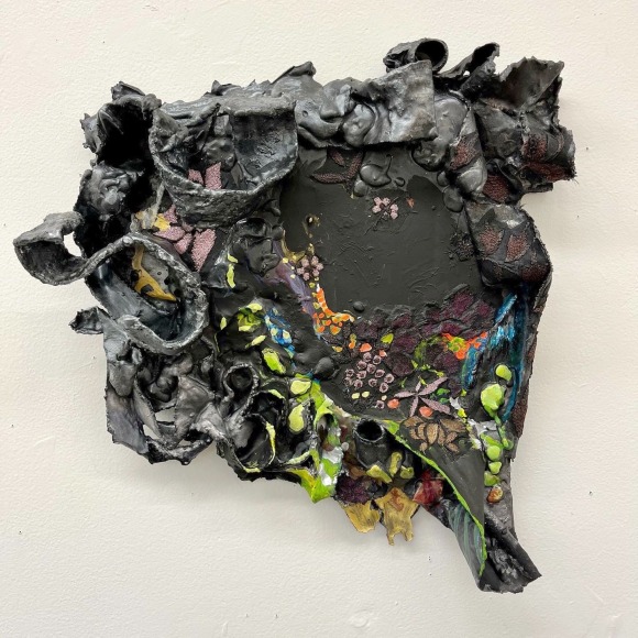 Shaped canvas, painted lack with plaster swirls and painted floral decorations