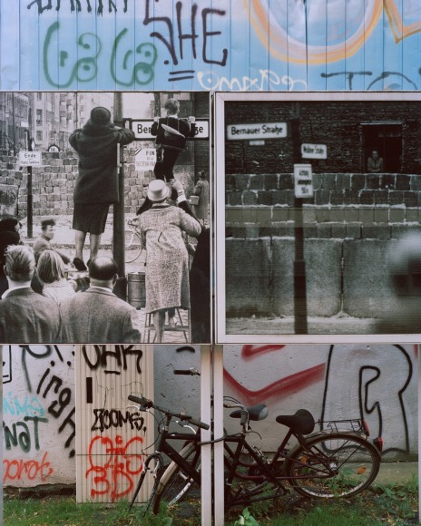 Photograph of side of wall with archival images and graffiti
