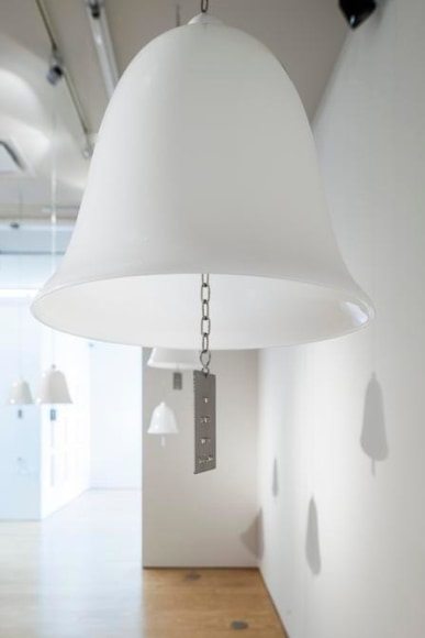 Marie Orensanz, ...in honor... of whom?, 1999-2015, 20 white opaline bells (9.5 x 10.2 in each) with stainless steel tags (3.1 x 1.8 in each), Installation view, 2015.