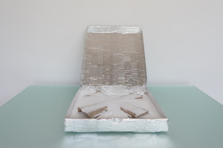 Ramiro Chaves, XNY, 2013. Pizza box, aluminum adhesive tape incised by typewriter, salt and cardboard, 4 in. x 33 3/4 in. x 16 1/2 in.