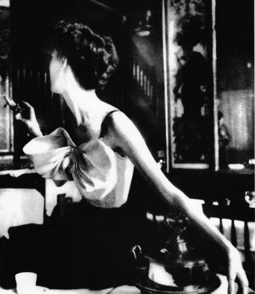 Lillian Bassman, Across the Restaurant: Barbara Mullen in a dress by Jacques Fath at Le Grand Vefour, Paris. Harper's Bazaar, 1949