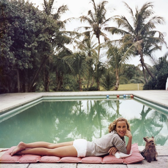 Slim Aarons, Having a Topping Time, 1959: Socialite Alice Topping relaxing poolside in Palm Beach