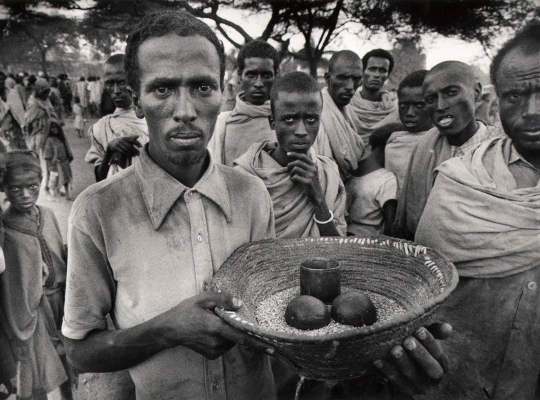 22. A Week of Provisions: A man holds a week of provisions provided by one of the non-governmental organizations that responded to the famine crisis in Ethiopia, 1984.
