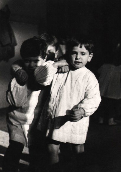 28. Renzo Tortelli, Piccolo Mondo, 1958&ndash;1959. High contrast image. Two young boys walk towards the camera with arms around each other's shoulders.