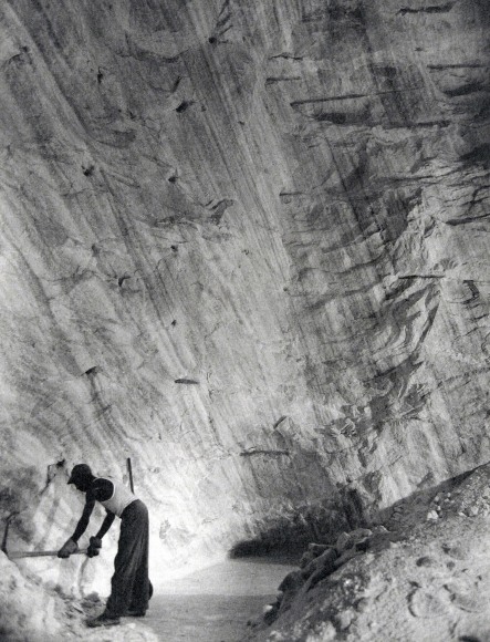 Harold Haliday Costain, Clearing the Path Along the Base of the Cliff, The Great Avery Island Salt Mine, 1934. A worker wields a pickaxe in the lower left corner of the frame.