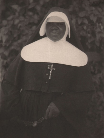 Doris Ulmann, Untitled (African American nun), ​1928&ndash;1934. Woman stands against an ivy wall, looking to camera.