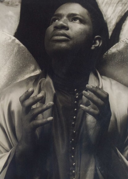 34. Carl Van Vechten, Ossie Davis as Gabriel, Greener Pastures, 1951. Bust-length portrait of subject with hands raised in front of his chest, eyes cast up and to the left.