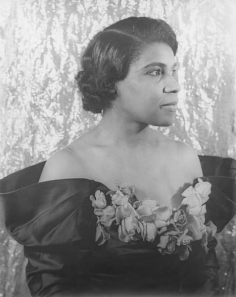11. Carl Van Vechten, Marian Anderson, 1940. Bust-length portrait with subject in an off-shoulder floral gown in partial profile facing the right of the frame.