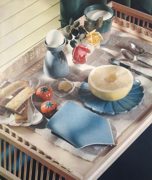 Hi Williams, Untitled, c. 1937. Color still life composition of a tray table featuring a glass of milk, a halved citrus fruit, an egg, flowers, bread, utensils, etc.